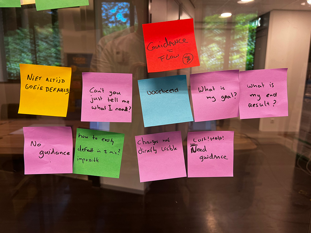Sticky notes on a glass wall with phrases such as “No guidance”, “Lost! Help! Need guidance” and “Guidance = flow”.